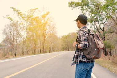 Doğa arka planda mutlu Asya hipster adam sırt çantası