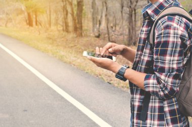 Doğa arka planda mutlu Asya hipster adam sırt çantası