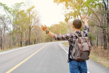 Doğa arka planda mutlu Asya hipster adam sırt çantası