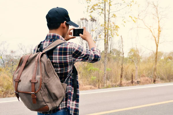 Feliz asiático hipster homem mochila no natureza fundo — Fotografia de Stock