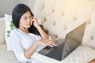 Güzel genç kadın odaya evde bir bilgisayar kullanarak