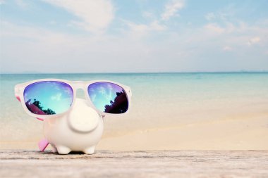 Kumbara ve sunglass tablo ve deniz arka plan üzerinde