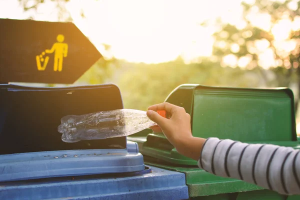 Nahaufnahme Mädchen Hand hält leere Flasche in den Papierkorb — Stockfoto