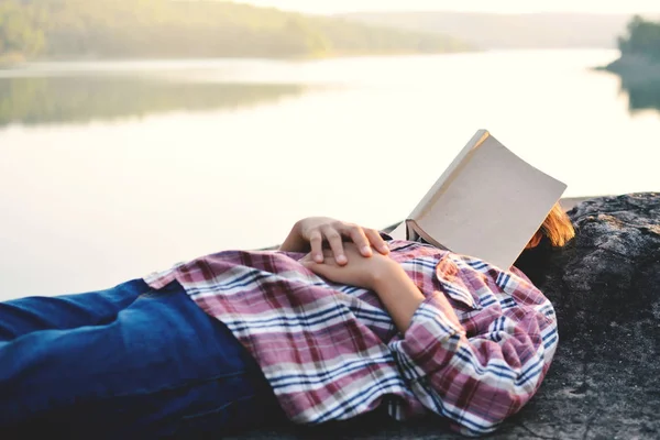 Ragazza dormire con libro vicino fiume e natura sfondo — Foto Stock