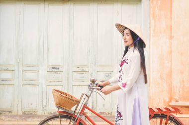 Güzel kadınlarla Vietnam Ao Dai gelinlik ve eski şehirde kırmızı bisiklet