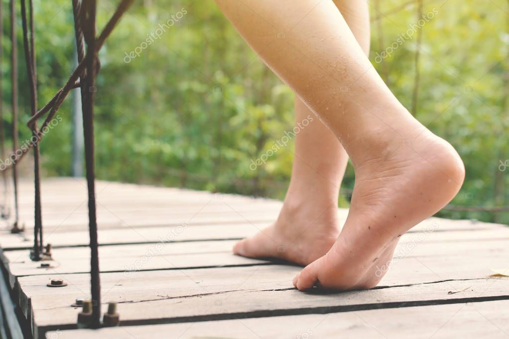 Feet women walking on bridge in nature forest background