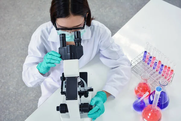 Científica femenina usando experimento de microscopio —  Fotos de Stock