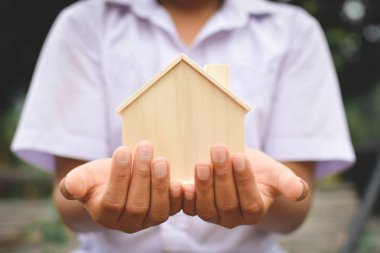 Küçük ahşap ev tutan eller erkek