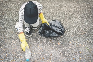 Kız el sarı eldiven boş şişe plastik depo gözü torbaya tespit