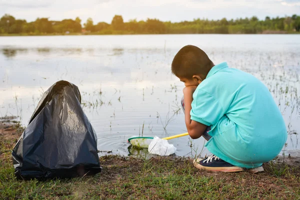 Mano de niño en guantes amarillos recogiendo vacío de botella de plástico, concepto voluntario — Foto de Stock