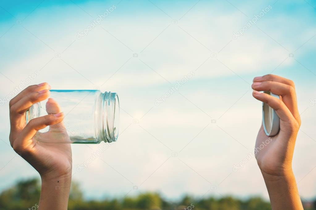 Hands holding glass jar for keeping fresh air 
