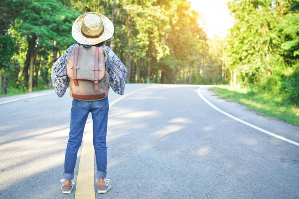 Gelukkig Aziatisch meisje rugzak op de weg en bos achtergrond — Stockfoto