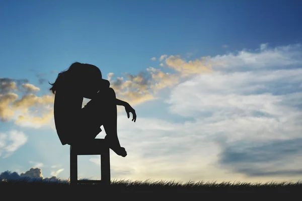 Silhouette trauriger Frauen, die entmutigt auf Stuhl sitzen — Stockfoto