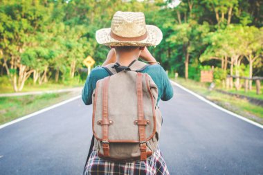 Yol ve orman arka planda mutlu Asyalı çocuk sırt çantası