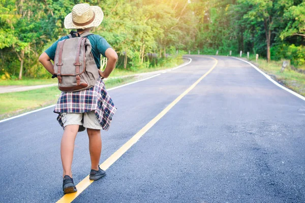 Yol ve orman arka planda mutlu Asyalı çocuk sırt çantası