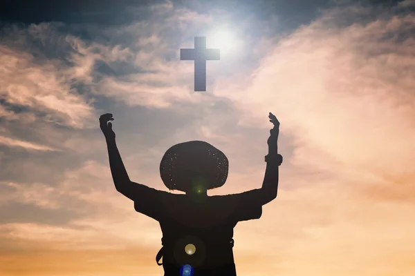 Silhueta de rapaz mãos abertas e cruz — Fotografia de Stock