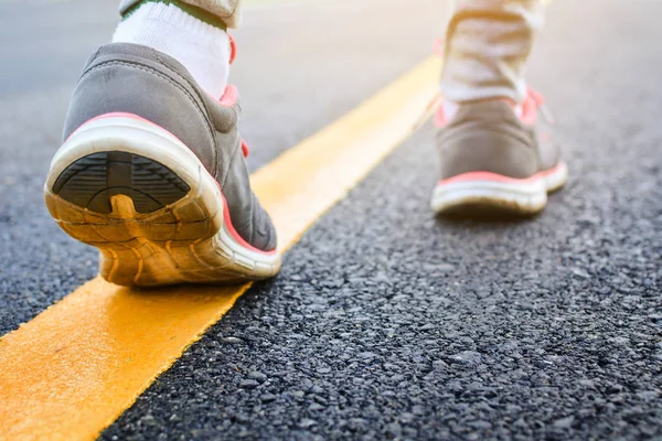 stock image Feet of girl walking in the road , concept exercise