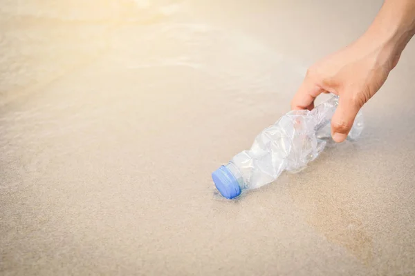 Mujer de la mano recogiendo botella de plástico — Foto de Stock