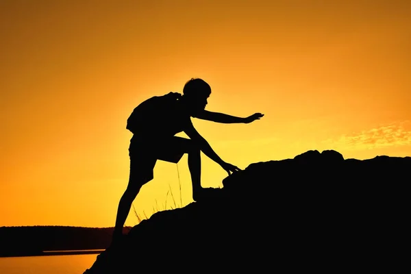 Silueta de hombre caminando a la cima de la montaña —  Fotos de Stock