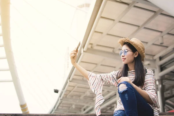 アジアの女性観光バンコク旅行 リラックス休暇流行に敏感な生活時間の中にスマート フォンの Selfie を使用して — ストック写真