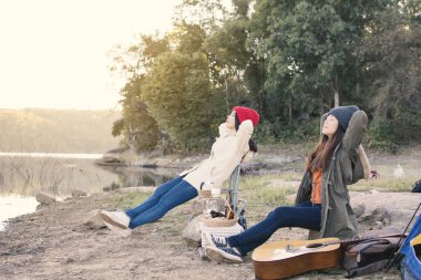 Mutlu Asyalı kadınlar rahatlama kamp ortaklık, seçici ve yumuşak odak, hippi tarzı tonunu ve doğa kış sezonu, kavram seyahat