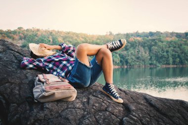 Doğa, tatil kavramı seyahat, seçici ve yumuşak odak, hippi tarzı tonunu Relax zamanında kayaya uyuyan çocuk backpacker