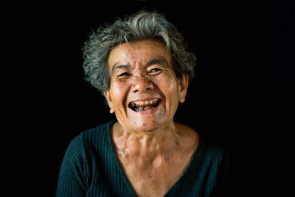 Happy Asian old woman smiling and joyful on black background