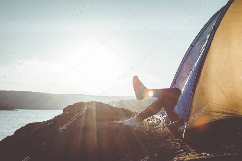 Silhouette feet woman relaxing in tent during camping, concept travel and camping ,selective and soft focus,tone of hipster style