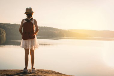 Asyalı kız sırt çantasında doğa günbatımı, tatil kavramı seyahat, seçici ve yumuşak odak, renk tonu hippi tarzı Relax zamanında sırasında