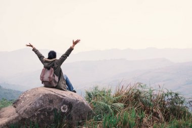 Mutlu kadın heyecan verici duygu zaman tatil seyahat kavramı, seçici ve yumuşak odak, yenilikçi stili rengini Relax rock açık eller en iyi Hill'de oturan