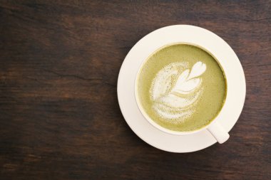 Yeşil çay bardağı rahatlatıcı, hipster sesi ve yumuşak odak kafeterya salonu zamanında