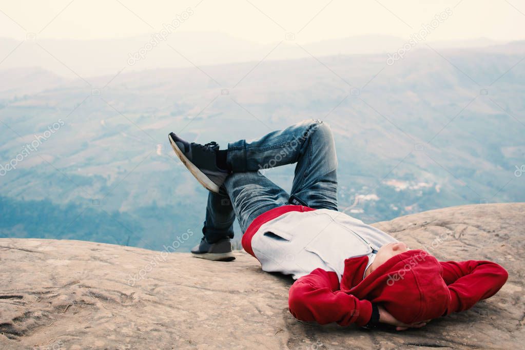 Relaxing moment Asian tourist sleeping on rock ,enjoying time on holiday concept ,color of vintage tone