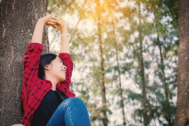 Zaman tatil kavramı, vintage sesi ve yumuşak odak rengini zevk rahatlatıcı ve park, büyük ağacın altında oturan mutlu an hipster kadın