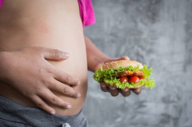 Yakın şişko mide kadar hamburger, kavram sağlıklı yeme keyfini ve kilo, seçici ve yumuşak odak