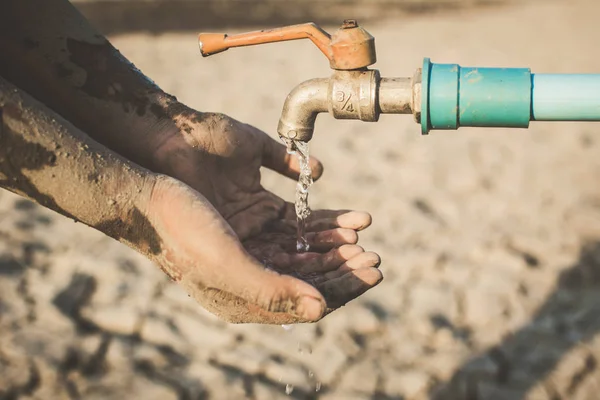 少年の手が地面の亀裂 概念の干ばつ 水危機の不足いくつかの水を飲みたいです — ストック写真