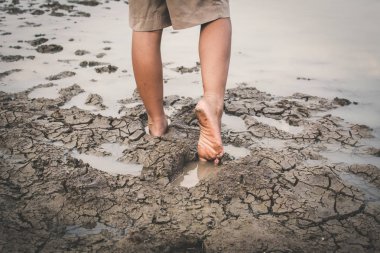 Kuru zemin .concept umut ve kuraklık ayak üzerinde yürüyen çocuk kırık
