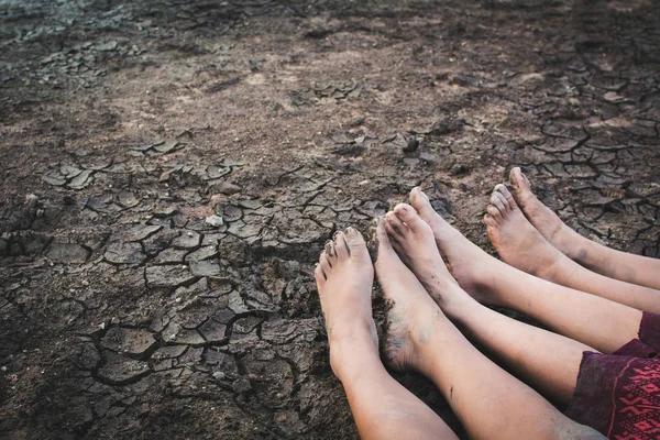 Feet of children on cracked dry ground .concept hope and drought