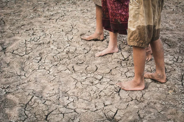Feet of children walking on cracked dry ground .concept hope and drought