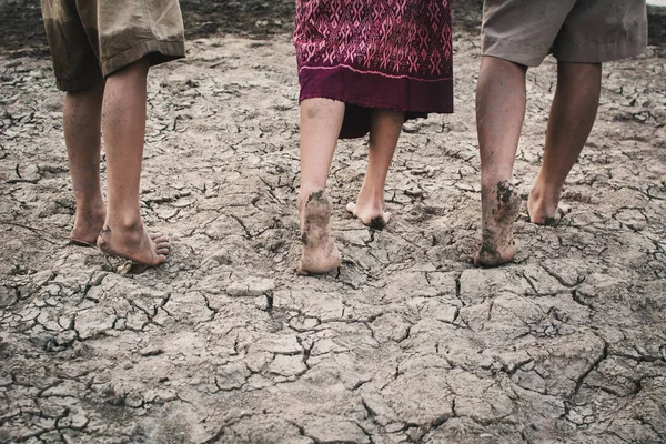 Feet of children walking on cracked dry ground .concept hope and drought