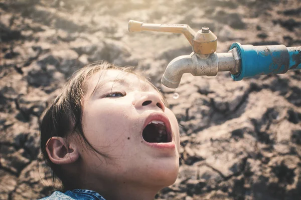 悲しい少女が地面の亀裂 概念の干ばつ 水危機の不足いくつかの水を飲みたいです — ストック写真