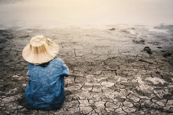 Sad girl and exhausted on cracked dry ground, Concept drought and shortage of water crisis