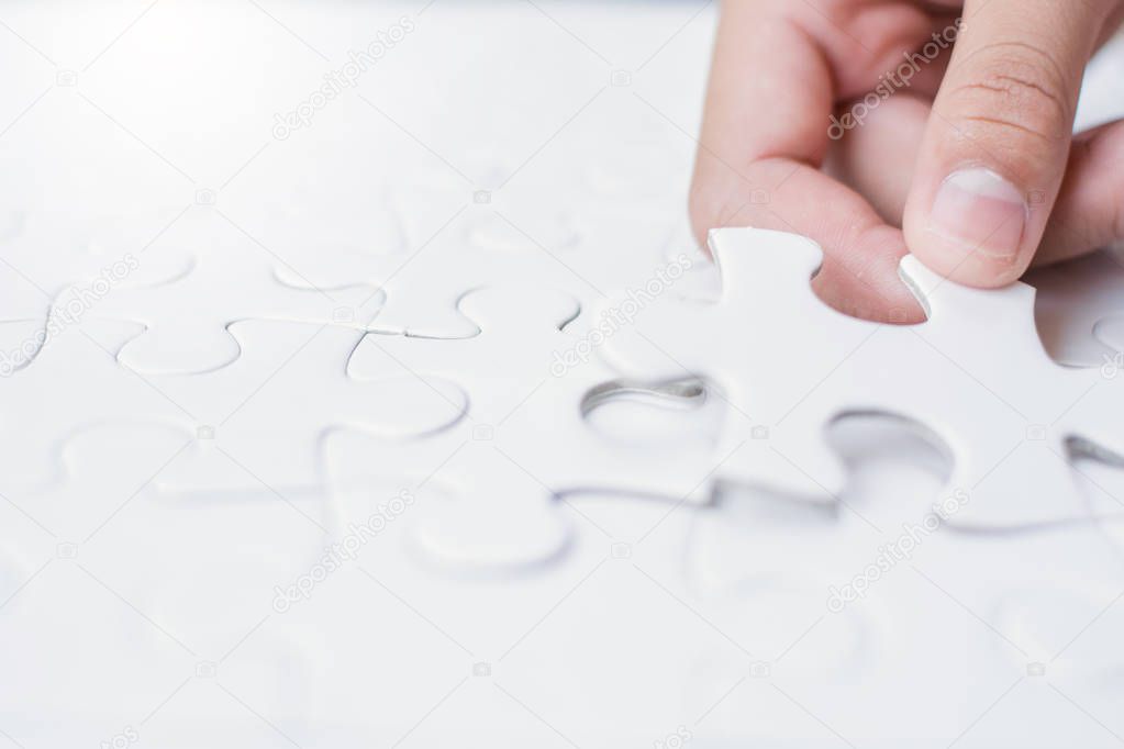 Close up girl's hand playing  jigsaw