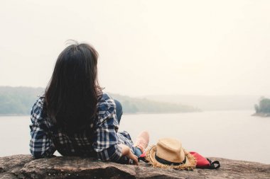 Mutlu Asyalı kadın tatil gezisi konseptinde dinleniyor, seçici ve yumuşak odaklı, yenilikçi tarzında.