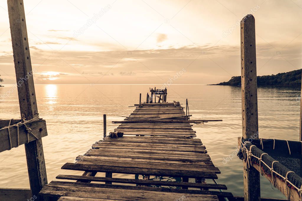 wood bridge in lake at sunset