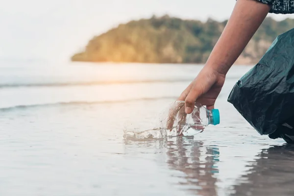 手拿起塑料瓶在海滩清洁 志愿的概念 — 图库照片