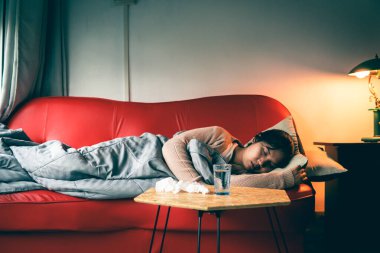 Hasta kadın soğuk algınlığı geçirir ve koltukta uyur..