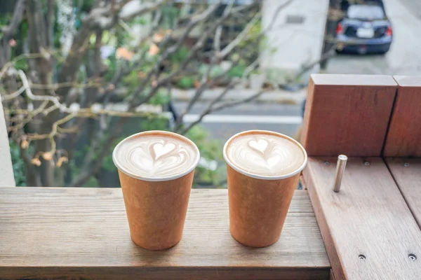 Heißer Kaffee Herzform in Pappbecher auf dem Tisch — Stockfoto