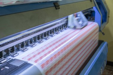 Etiket sayfaları üzerinde çalışan büyük formatlı mürekkep püskürtmeli yazıcı