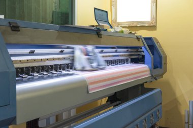 Etiket sayfaları üzerinde çalışan büyük formatlı mürekkep püskürtmeli yazıcı