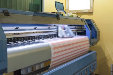 Etiket sayfaları üzerinde çalışan büyük formatlı mürekkep püskürtmeli yazıcı